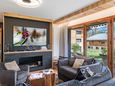 a living room with a tv on a wall at Appartement neuf, 4 personnes, terrasse, 15 min du centre de Megève - FR-1-569-96 in Megève