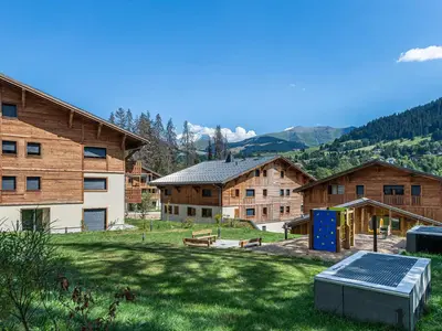 a group of buildings with a yard with a solarium at Appartement neuf, 4 personnes, terrasse, 15 min du centre de Megève - FR-1-569-96 in Megève