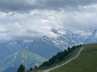 a road on a hill with mountains in the background at Residence le Grand Panorama - with garden & view in Saint-Gervais-les-Bains