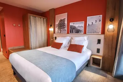 a bedroom with a large white bed with red walls at Belambra Clubs Flaine Panorama in Flaine