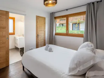 a bedroom with a white bed and a window at Spacieux appartement pour familles près du centre avec parking - FR-1-569-85 in Megève