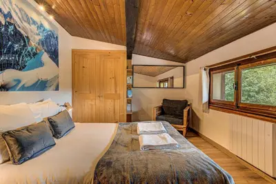 a bedroom with a large bed and a window at Apartment Les Nantillons - Alpes Travel - Central Chamonix (sleeps 6-8) in Chamonix-Mont-Blanc