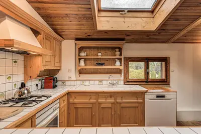 a large kitchen with wooden cabinets and a window at Apartment Les Nantillons - Alpes Travel - Central Chamonix (sleeps 6-8) in Chamonix-Mont-Blanc
