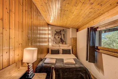 a small bedroom with a bed in a wooden room at Apartment Les Nantillons - Alpes Travel - Central Chamonix (sleeps 6-8) in Chamonix-Mont-Blanc