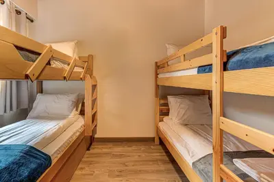 two bunk beds in a small room with another bunk bed at Apartment Les Nantillons - Alpes Travel - Central Chamonix (sleeps 6-8) in Chamonix-Mont-Blanc