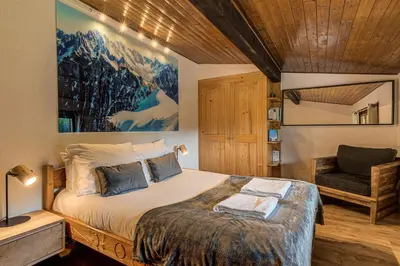 a bedroom with a bed and a chair in it at Apartment Les Nantillons - Alpes Travel - Central Chamonix (sleeps 6-8) in Chamonix-Mont-Blanc