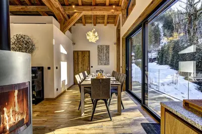 a dining room with a fireplace and a table and chairs at Chalet Silver Forest in Chamonix-Mont-Blanc