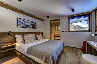 a bedroom with a bed and a window with mountains at Chalet Silver Forest in Chamonix-Mont-Blanc