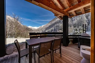a table and chairs on a deck with a view at Chalet Silver Forest in Chamonix-Mont-Blanc