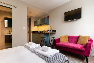 a bedroom with a bed and a pink couch at Beautiful cosy, modern studio in Chamonix centre in Chamonix-Mont-Blanc