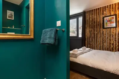 a blue room with a bed and a mirror at Beautiful cosy, modern studio in Chamonix centre in Chamonix-Mont-Blanc