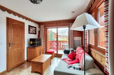 a living room with a couch and a television at Résidence Les Fermes du Soleil - maeva Home - Appartement 3 pièces 6 personnes - Prestige MAE-0374 in Les Carroz d'Araches