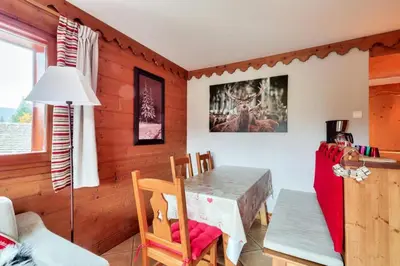 a dining room with a table and chairs in a room at Résidence Les Fermes du Soleil - maeva Home - Appartement 3 pièces 6 personnes - Prestige MAE-0374 in Les Carroz d'Araches