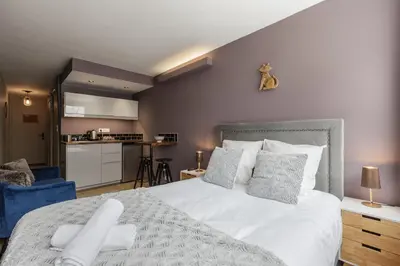 a bedroom with a large white bed and a kitchen at Beautiful mountain view studio by the lake in Chamonix-Mont-Blanc