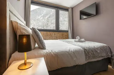 a bedroom with a bed and a window at Beautiful mountain view studio by the lake in Chamonix-Mont-Blanc