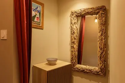a bathroom with a mirror and a vase on a table at Beautiful mountain view studio by the lake in Chamonix-Mont-Blanc