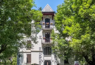 a white building with a balcony with flowers on it at La Rose de Glace in Chamonix-Mont-Blanc