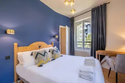 a bedroom with a large bed with a blue wall at La Rose de Glace in Chamonix-Mont-Blanc