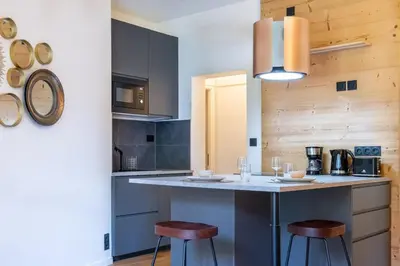 a kitchen with a counter and two stools at La Rose de Glace in Chamonix-Mont-Blanc