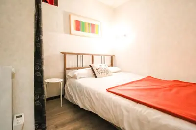 a bedroom with a bed with a red blanket on it at Studio Cabine Sud, centre de Flaine, linge et menage compris in Flaine