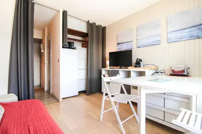 a room with a desk and a table with chairs at Studio Cabine Sud, centre de Flaine, linge et menage compris in Flaine