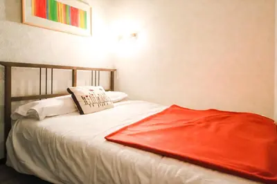 a bed with a red blanket on top of it at Studio Cabine Sud, centre de Flaine, linge et menage compris in Flaine