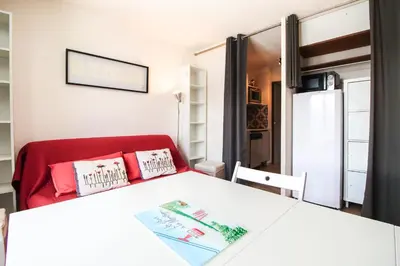 a room with a white table and a red chair at Studio Cabine Sud, centre de Flaine, linge et menage compris in Flaine