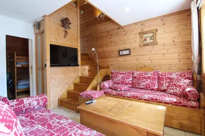 a living room with a red couch and a tv at Charming 4-bed Chalet, Mountain Views, Double Garage in Flaine