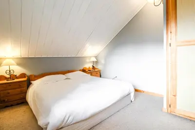 a bedroom with a white bed and a window at Charming 4-bed Chalet, Mountain Views, Double Garage in Flaine