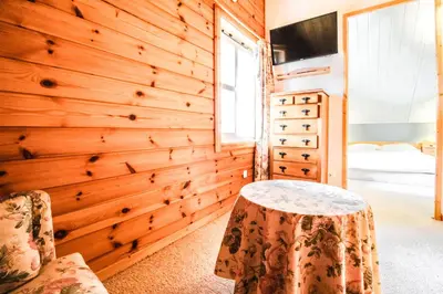 a room with a wooden wall with a table and a bed at Charming 4-bed Chalet, Mountain Views, Double Garage in Flaine