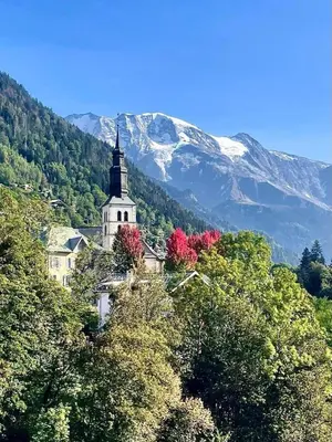a church sitting on top of a hill with trees at LE GL'ASSIE in Saint-Gervais-les-Bains