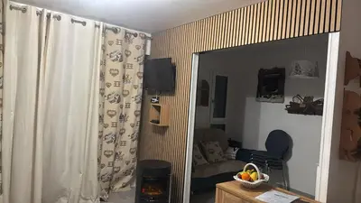 a living room with a mirror and a couch at LE GL'ASSIE in Saint-Gervais-les-Bains