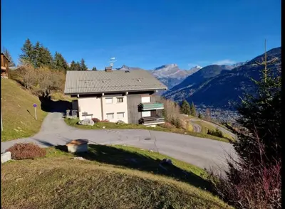 a house on the side of a hill with a road at LE GL'ASSIE in Saint-Gervais-les-Bains