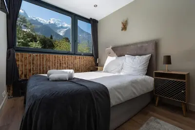 a bedroom with a bed and a large window at Modern apartment with the best Mont Blanc view! in Chamonix-Mont-Blanc
