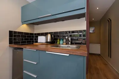 a kitchen with blue cabinets and a sink at Modern apartment with the best Mont Blanc view! in Chamonix-Mont-Blanc