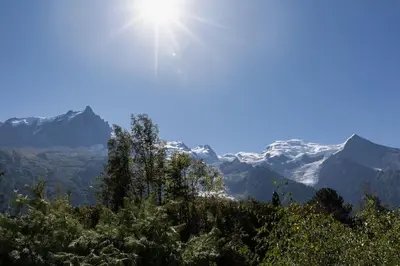 a view of the mountains with the sun in the sky at Modern apartment with the best Mont Blanc view! in Chamonix-Mont-Blanc