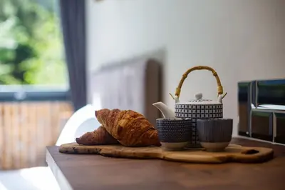 a table with two cups and a basket of bread at Modern apartment with the best Mont Blanc view! in Chamonix-Mont-Blanc