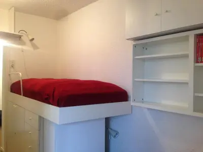 a room with a bed with a red seat in it at Appartment Aiguille Du Midi in Chamonix-Mont-Blanc