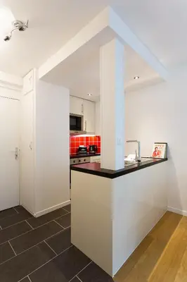 a kitchen with white cabinets and a counter top at Apartment Chamois Blanc 2 Centre Chamonix Mont Blanc in Chamonix-Mont-Blanc