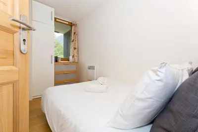 a bedroom with a white bed and a window at Apartment Chamois Blanc 2 Centre Chamonix Mont Blanc in Chamonix-Mont-Blanc