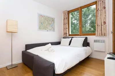 a large bed in a room with a window at Apartment Chamois Blanc 2 Centre Chamonix Mont Blanc in Chamonix-Mont-Blanc