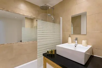 a bathroom with a sink and a tub and a mirror at Apartment Chamois Blanc 2 Centre Chamonix Mont Blanc in Chamonix-Mont-Blanc