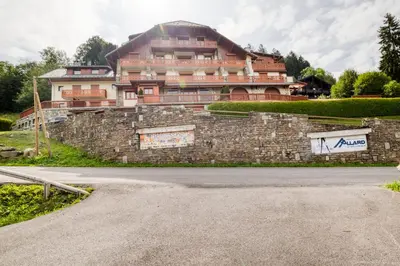a large building sitting on top of a stone wall at Appartement 2 chambres en centre-ville de Megève in Megève