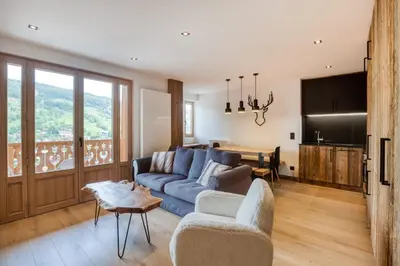 a living room with a blue couch and a table at Appartement 2 chambres en centre-ville de Megève in Megève