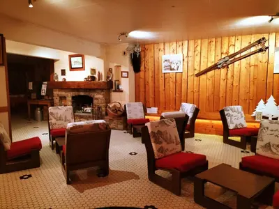 a living room with a group of chairs and a fireplace at Hotel et centre de vacances Le Choucas in Sixt