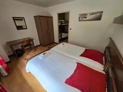 a bedroom with a large bed with red pillows at Hotel et centre de vacances Le Choucas in Sixt