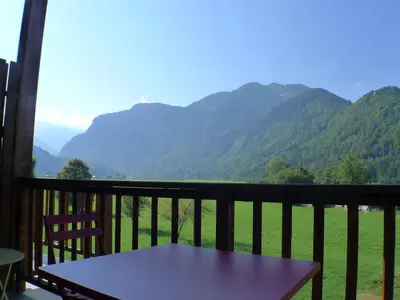 a table on a balcony with a view of mountains at Duplex T4 calme avec parking, animaux acceptés à Samoëns - FR-1-629-133 in Samoëns