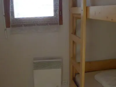 a room with a bunk bed and a window and a heater at Duplex T4 calme avec parking, animaux acceptés à Samoëns - FR-1-629-133 in Samoëns