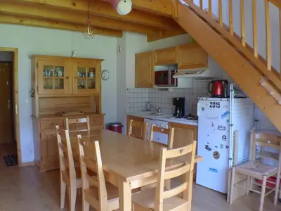 a kitchen with a wooden table and a white refrigerator at Duplex T4 calme avec parking, animaux acceptés à Samoëns - FR-1-629-133 in Samoëns