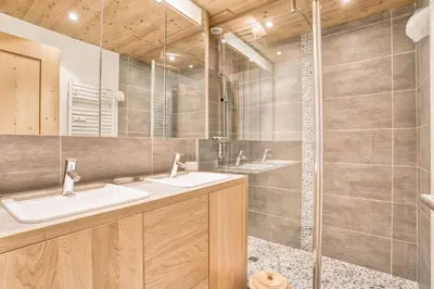 a bathroom with two sinks and a shower at Marmots in Megève